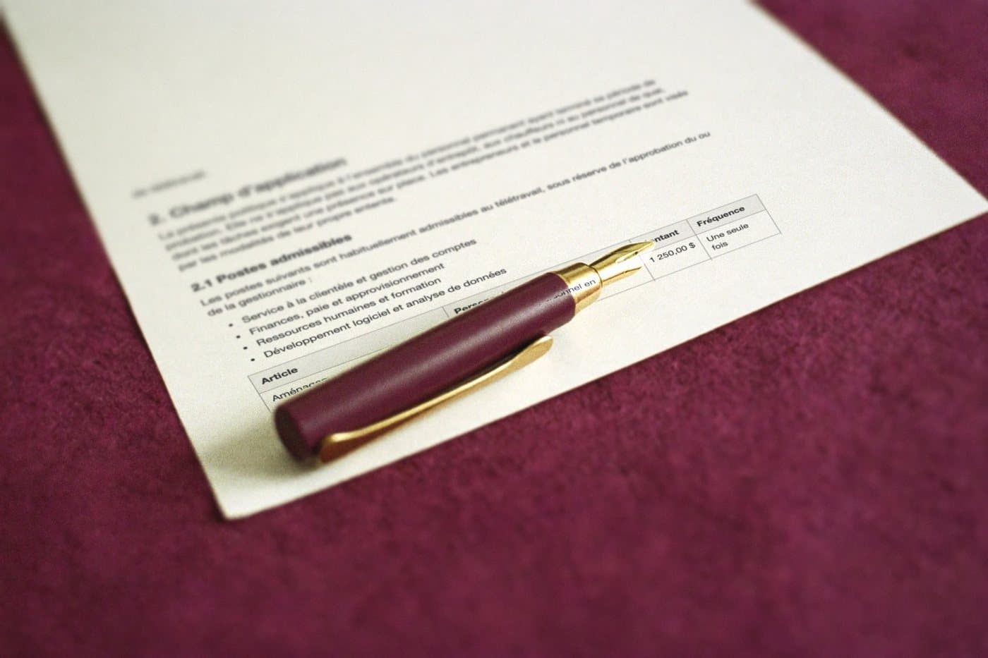 Close-up of the translated page: in the table, the amount written the Quebec way, 1 250,00 $, beside a fountain pen nib.